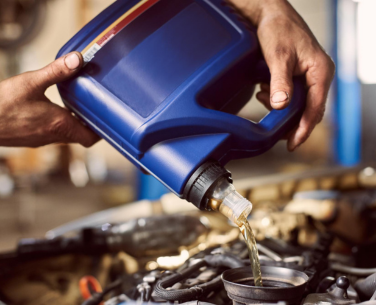 Pouring engine oil into a car engine